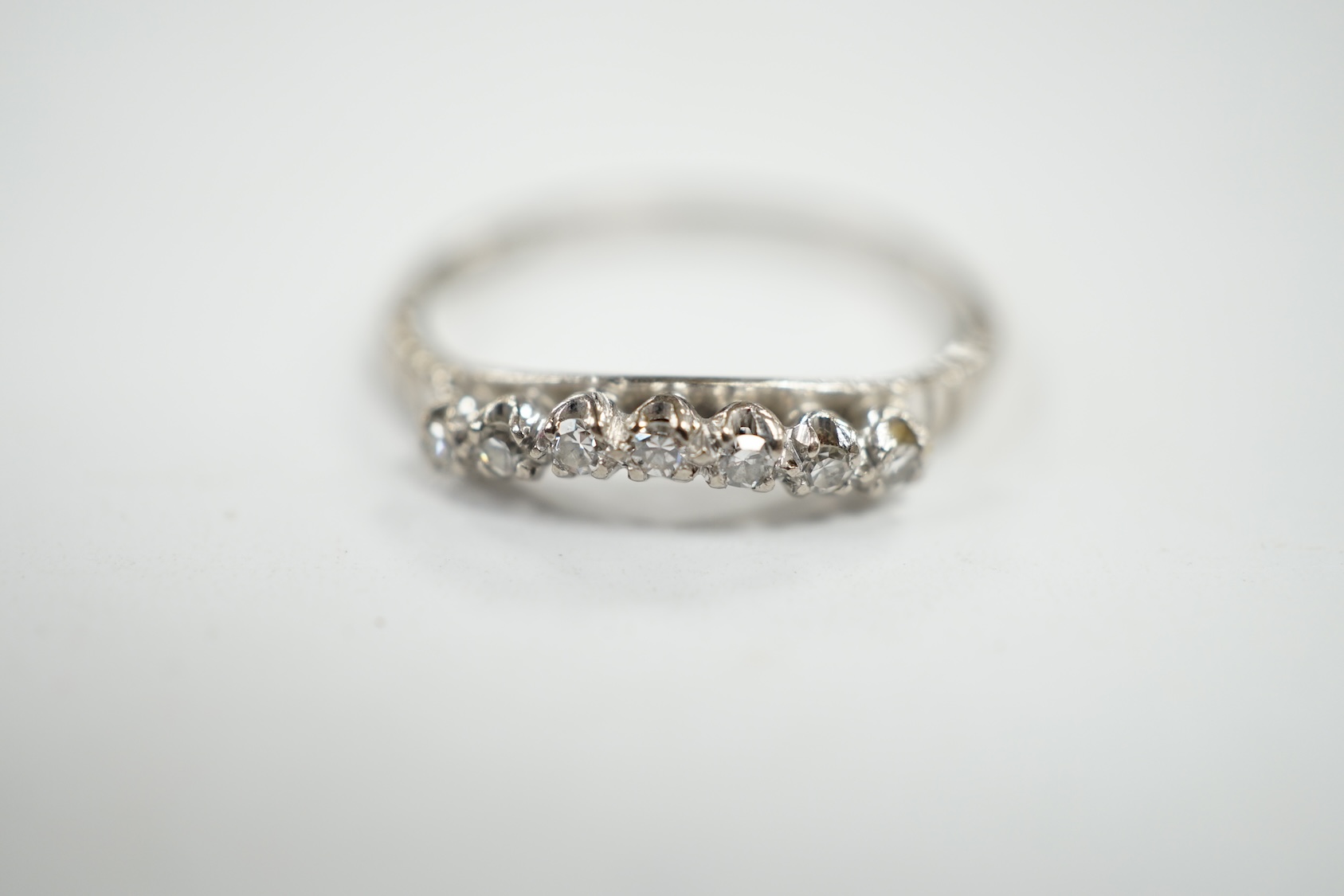 An 18ct, plat and seven stone diamond chip set 'chevron' half hoop ring, size O, gross weight 2.5 grams. Condition - fair